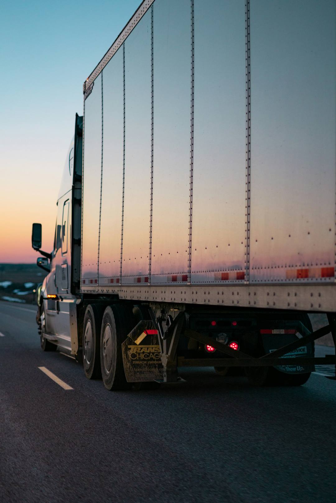 Weißer LKW auf der Landstraße bei Sonnenuntergang